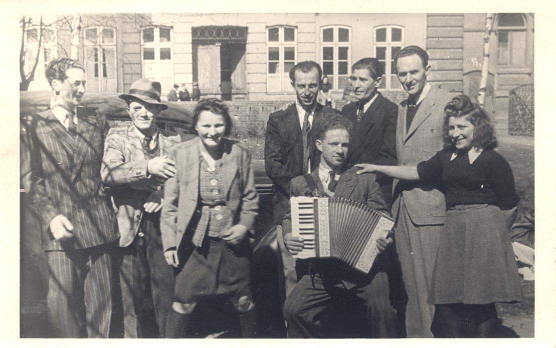 Holocaust-Überlebende auf dem Hof vor der Lübecker Synagoge.
Mit Ziehharmonika: Benjamin Gruszka, 1946(Jüdisches Museum)